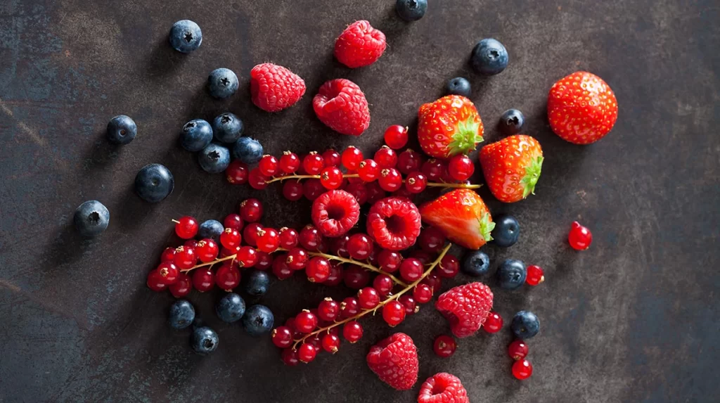 Frutos rojos sobre la mesa, como frutillas o arándanos