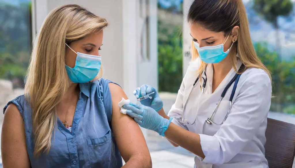 La vacuna contra el VPH siendo aplicada a una mujer por una médica
