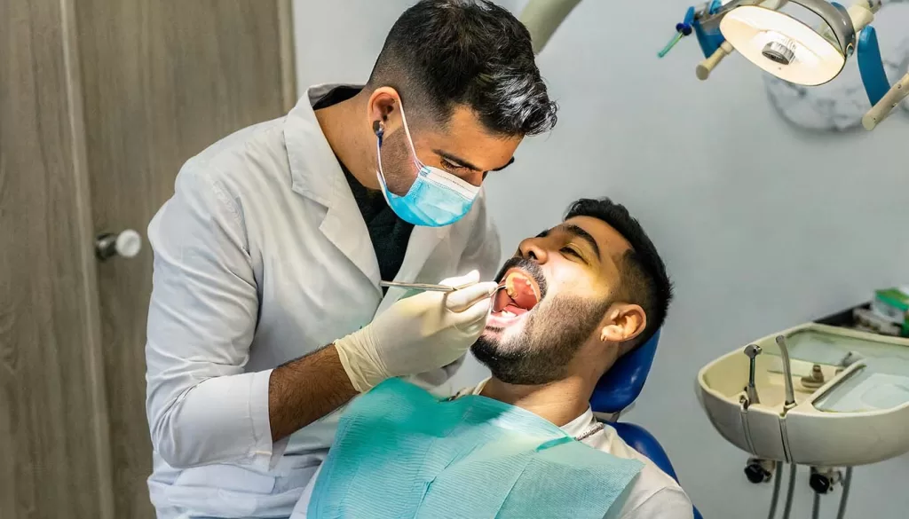 Un hombre siendo tratado por un odontólogo debido a su VPH oral
